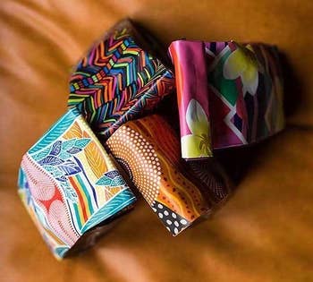 Four coffee bags with different patterns on the bag all sitting together. 