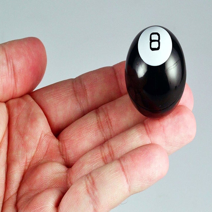 the magic 8 ball on the tip of someone's fingers