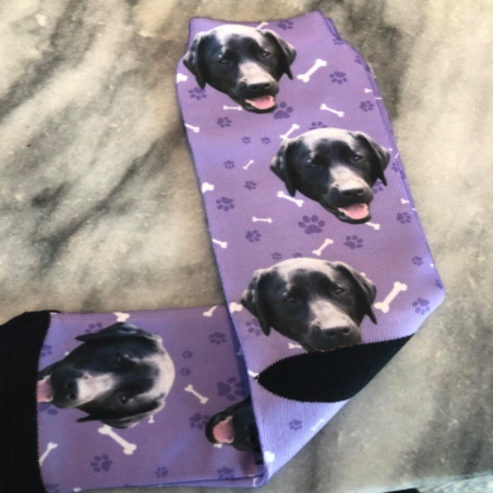 a reviewer photo of purple socks with their dog on it