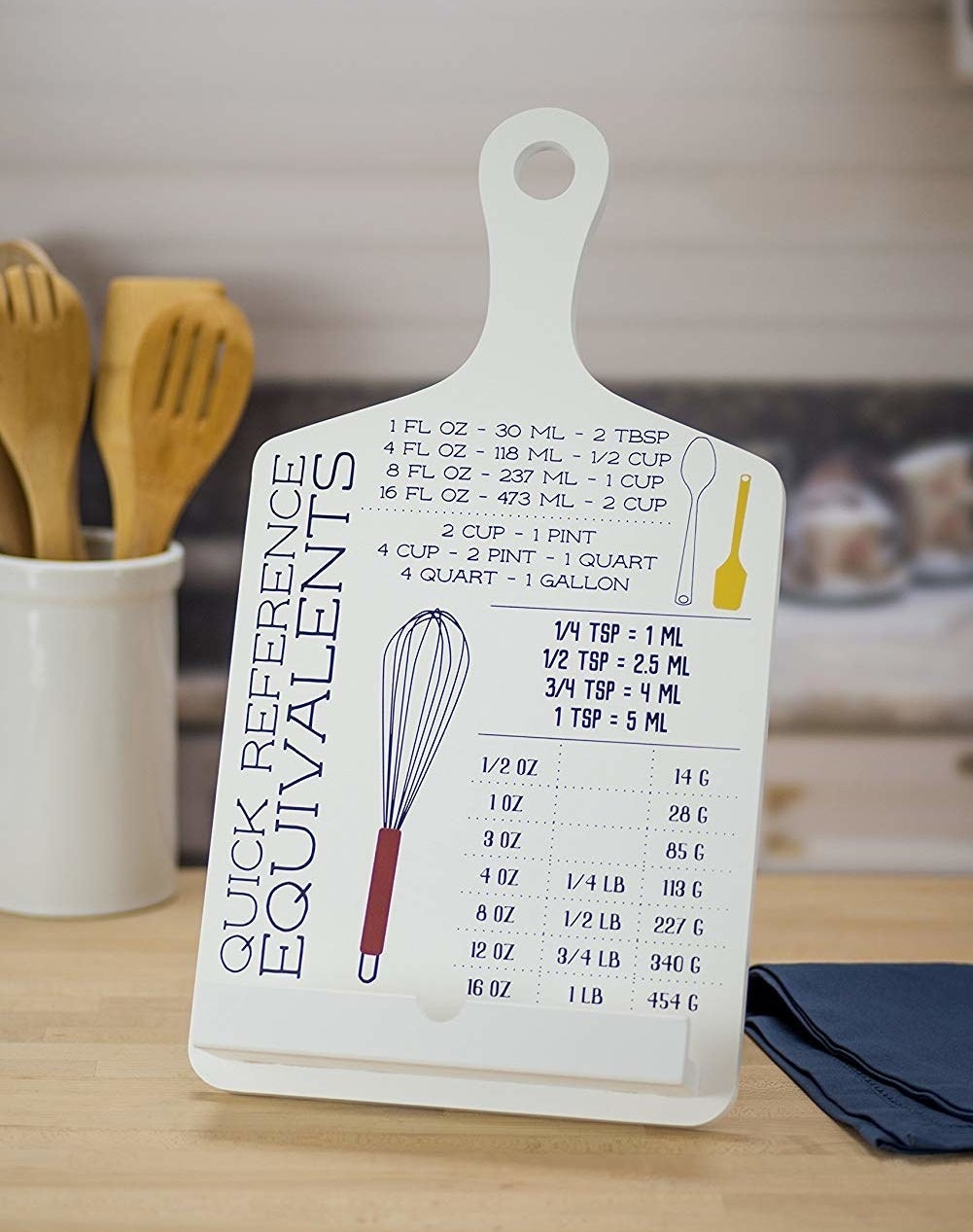 a tablet and cookbook stand with measurement conversions printed on the front