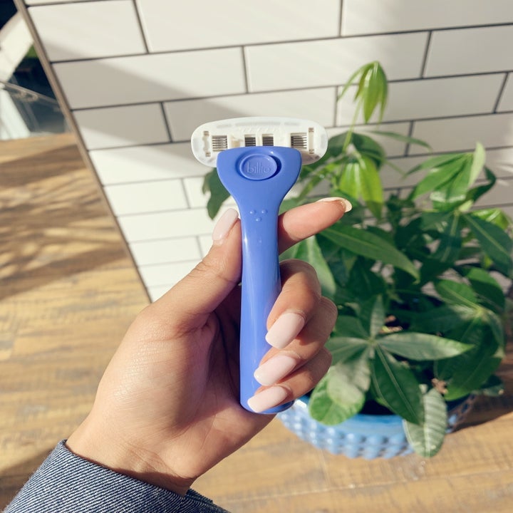 BuzzFeed editor holding the razor in her hand showing the blue handle and white head