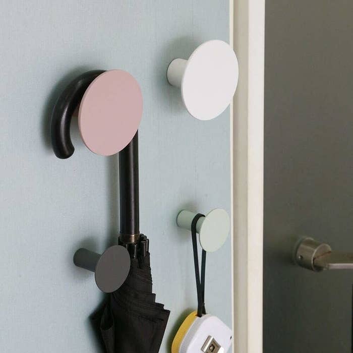 Two large circle hooks in pink and white and two small circle hooks in black and mint below with assorted things hanging from them