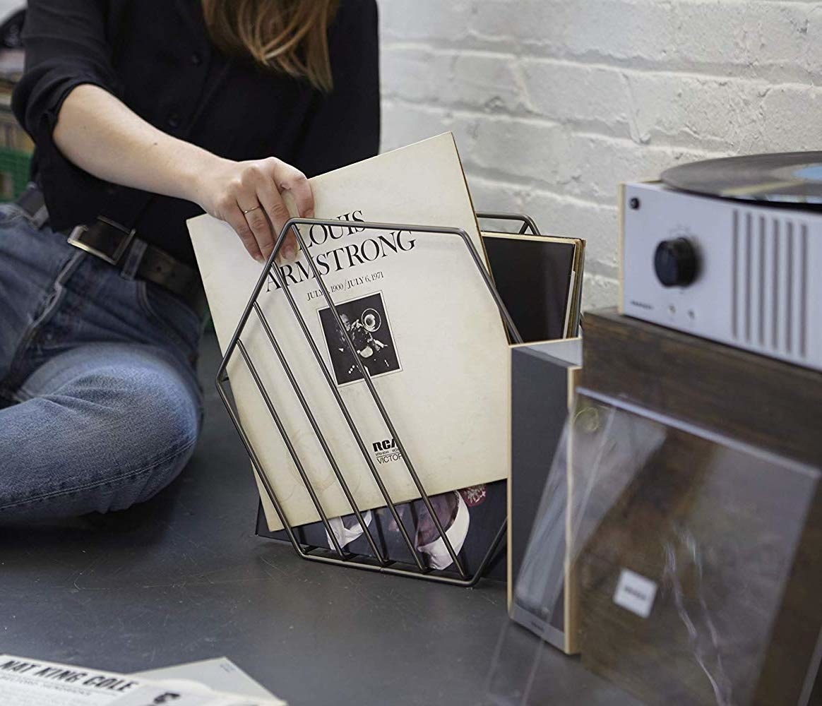 A person putting a record into the hexagonal record holder