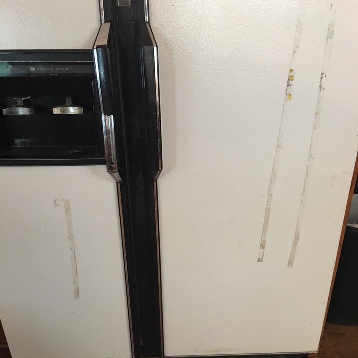 a dirty refrigerator door before being treated with the adhesive remover