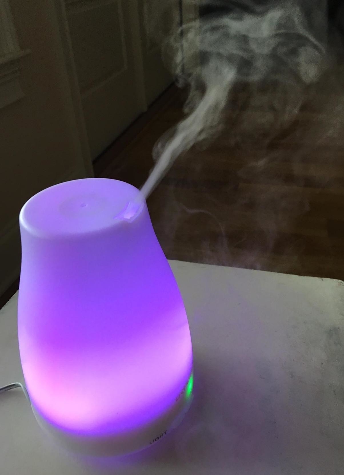 reviewer&#x27;s essential oil diffuser glowing in purple 