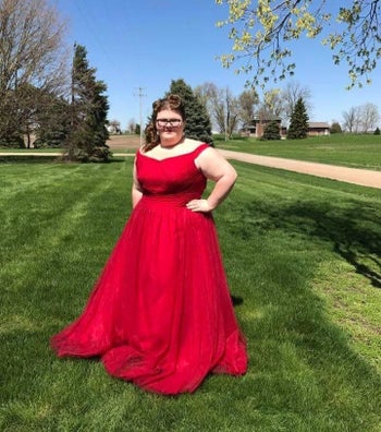 A reviewer wearing the ball gown in red 