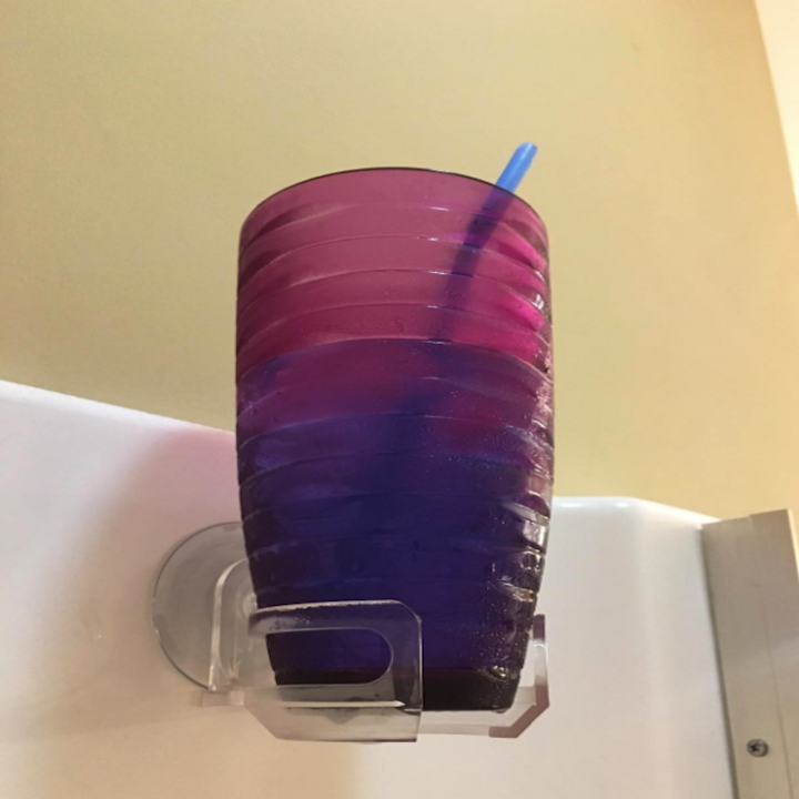 differen't reviewer's photo with the same cup holder with a plastic cup with a beverage and straw in it