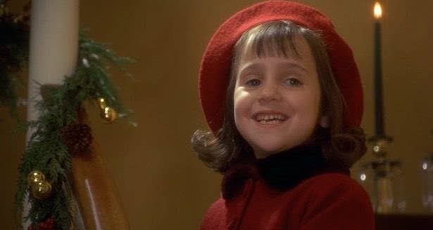 Mara Wilson smiling next to christmas decorations  in Miracle on 34th street