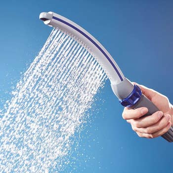 the curved handheld shower attachment with water flowing out of it