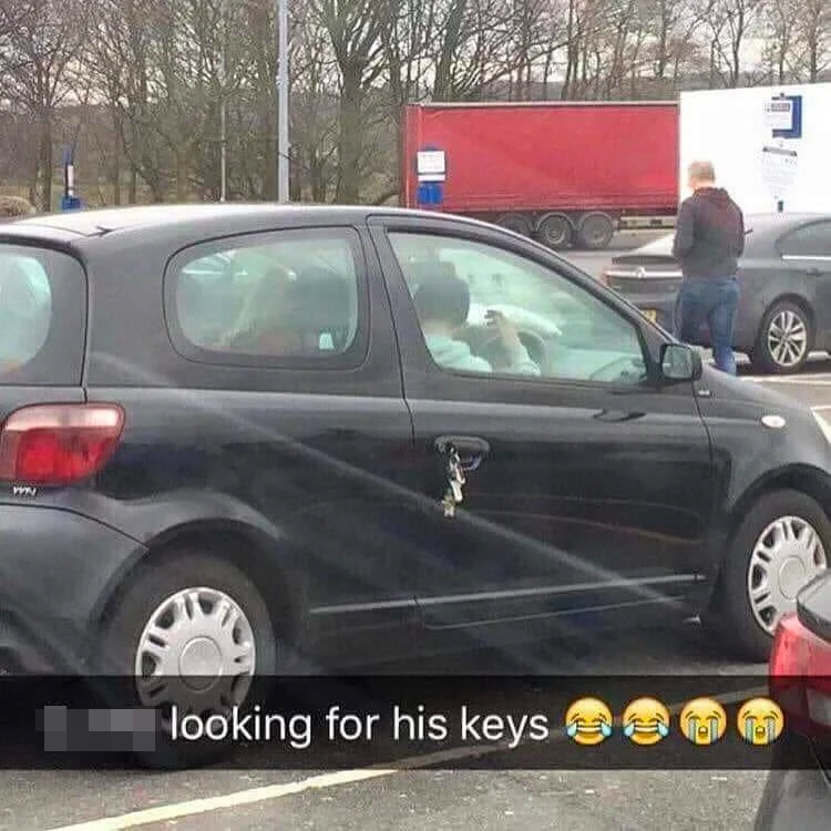 someone looking for keys inside their car, while the keys are right outside in the car door