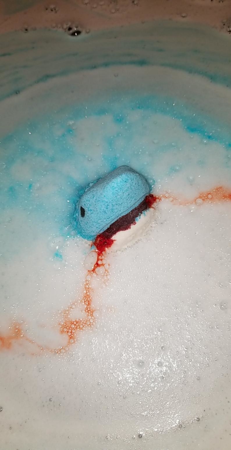 shark head bath bomb with red liquid coming from its sudsy mouth