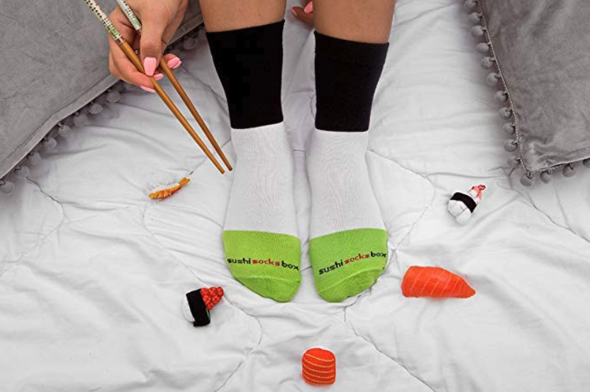 A person wearing crew socks and holding a pair of chopsticks