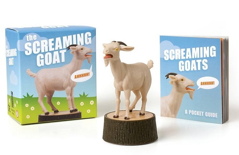 The goat standing on a stump figurine, its packaging, and the mini booklet
