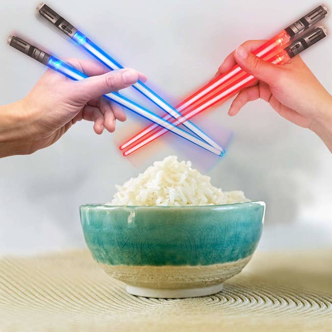 Two people holding the light-up chopsticks