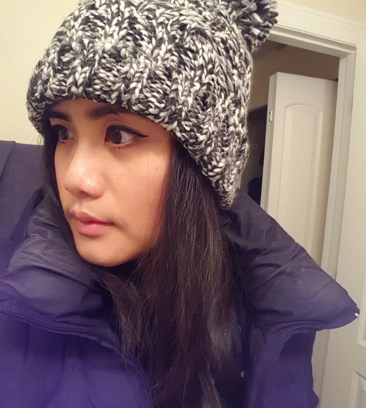 reviewer wearing the beanie in black, white, and gray 