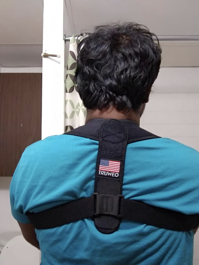 reviewer wearing the posture corrector on their back