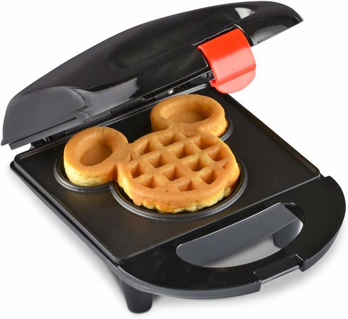 A small waffle iron on a plain background