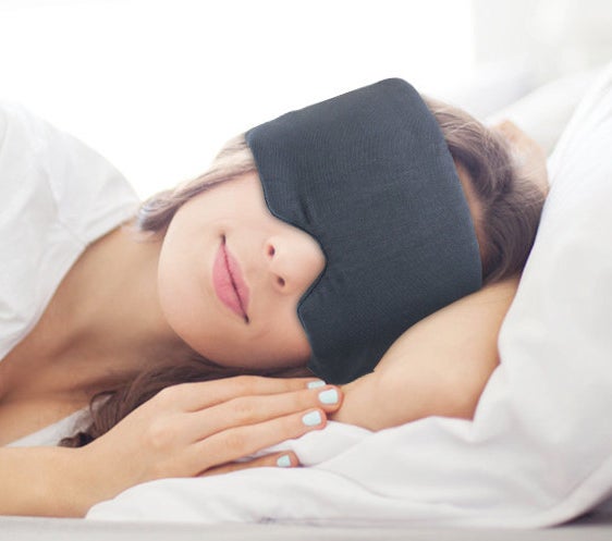 Model wearing the gray, full-coverage sleep mask 