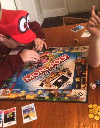 a family playing monopoly gamer edition