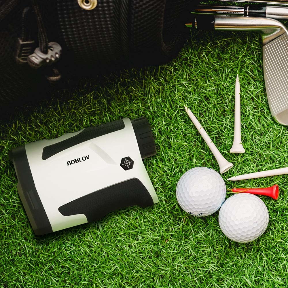 The range finder on the grass next to golf accessories