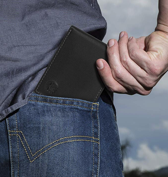 a person slipping a slim wallet in their back pocket