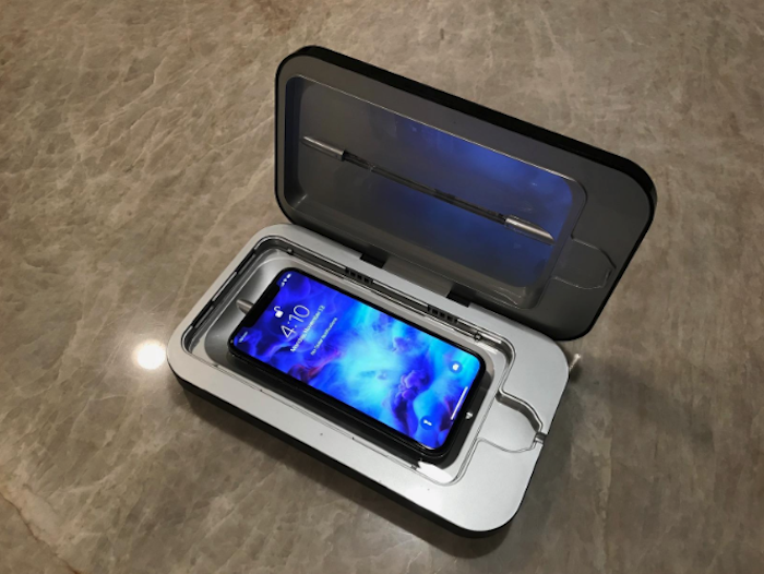 an Android smartphone sitting inside of the sanitizer case with the lid up