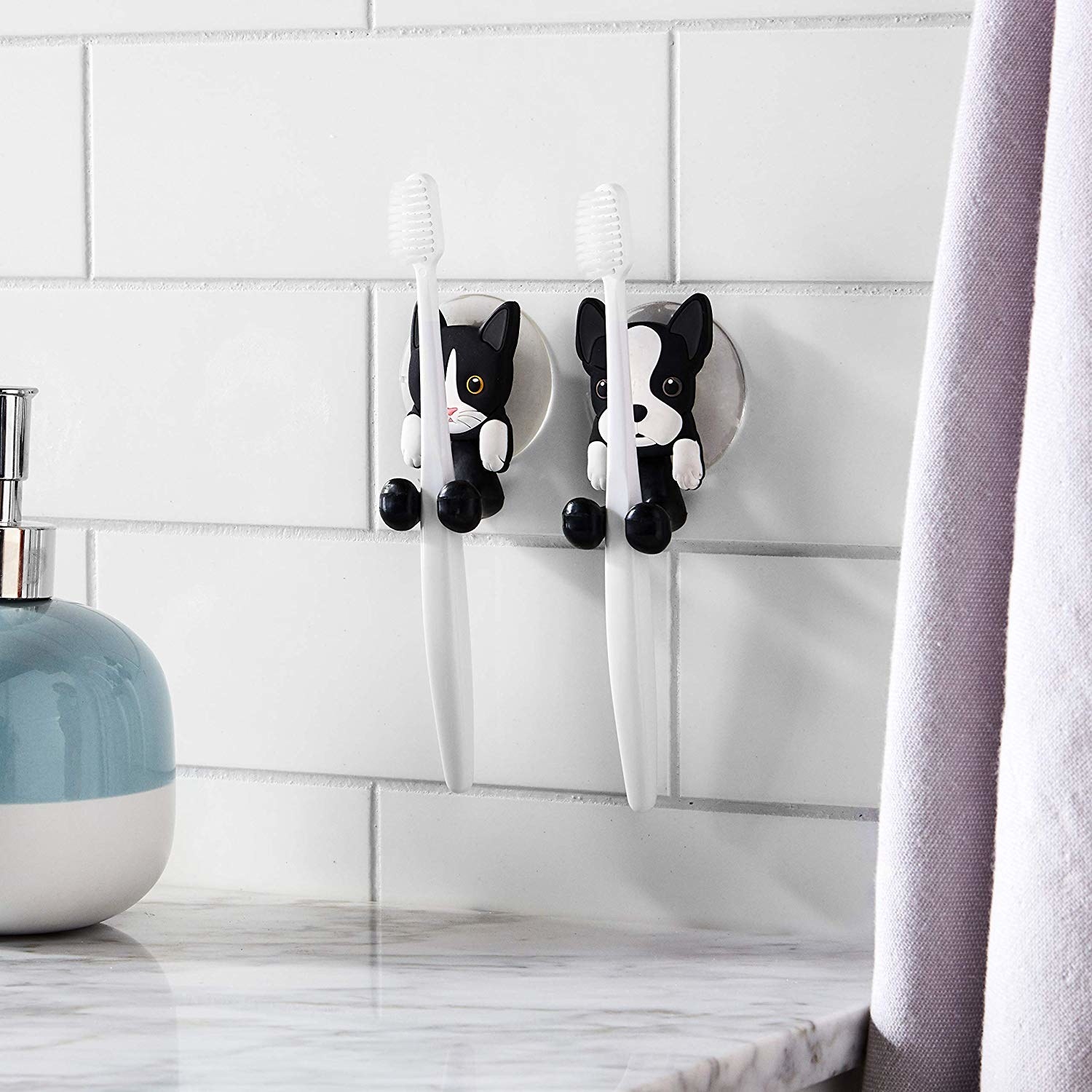The two toothbrush holders attached to a tile wall