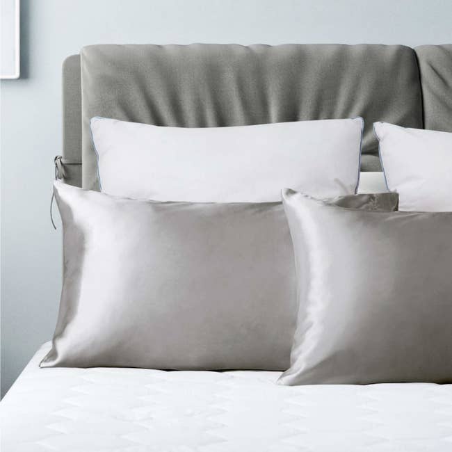 gray satin pillowcases on sleeping pillow on a bed