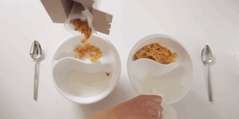 model pouring cereal and milk into a bowl and then spooning the cereal one side into the milk on the other side of the bowl
