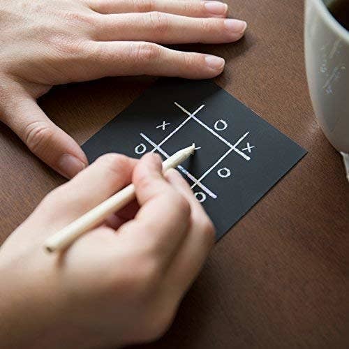 person placing tic-tac-toe on one of the notes