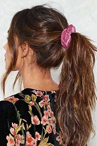 model wearing a pink velvet scrunchie with a messy ponytail