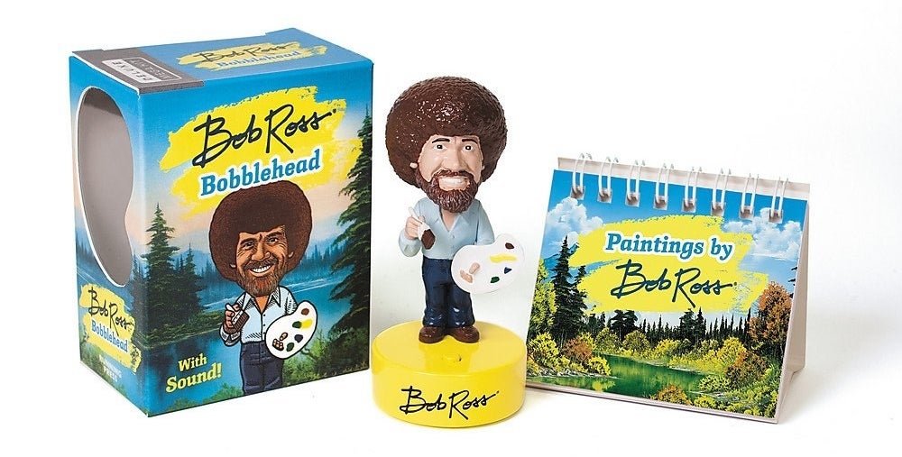 the Bob Ross bobble head with a book of paintings