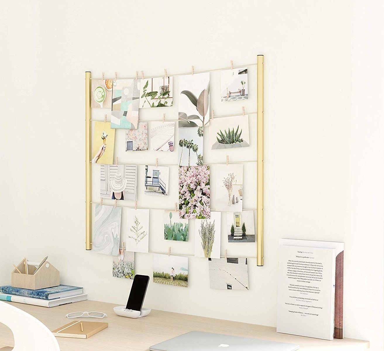 A clothespin photo display hanging above a desk