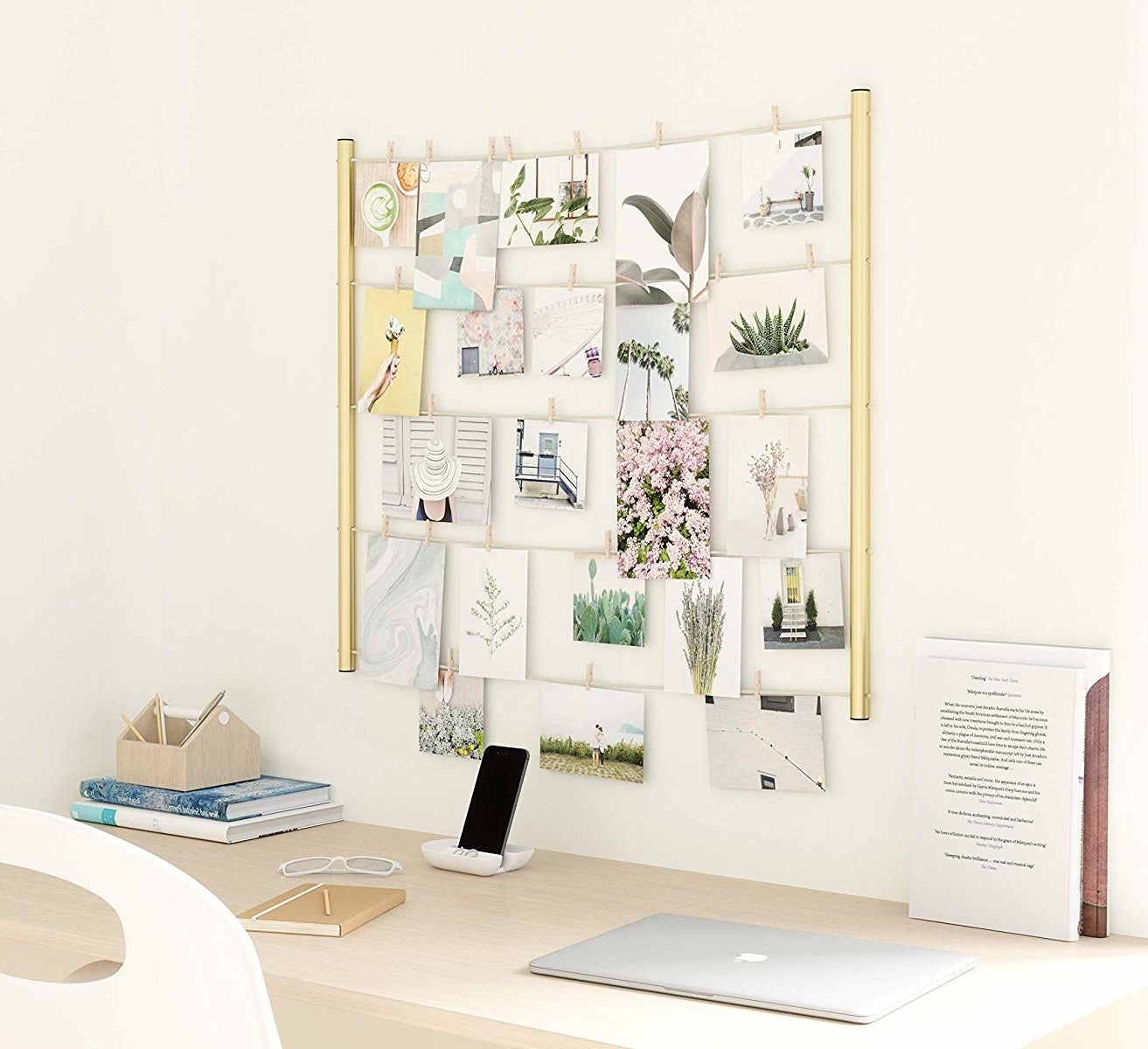 A clothespin photo display hanging above a desk