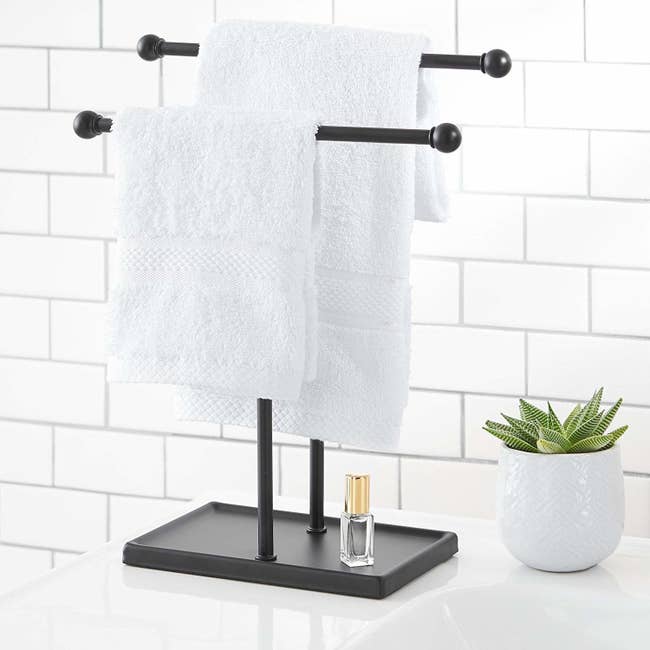 the two-tier towel holder in black with hand towels hanging from each one
