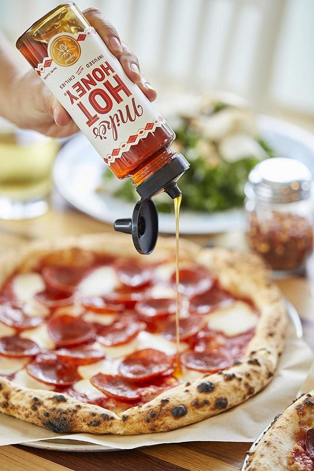 honey being drizzled onto a pizza
