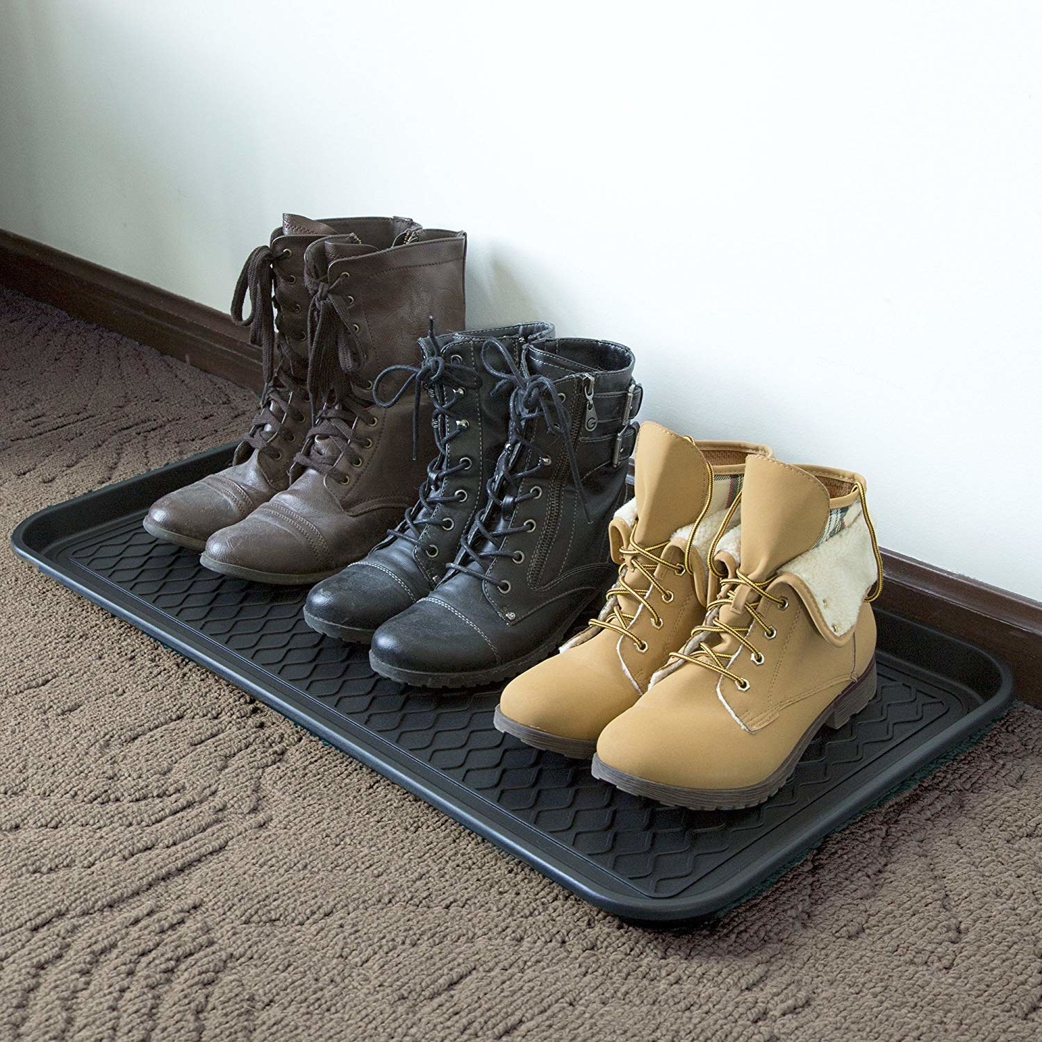 Tray on floor holding three pairs of boots