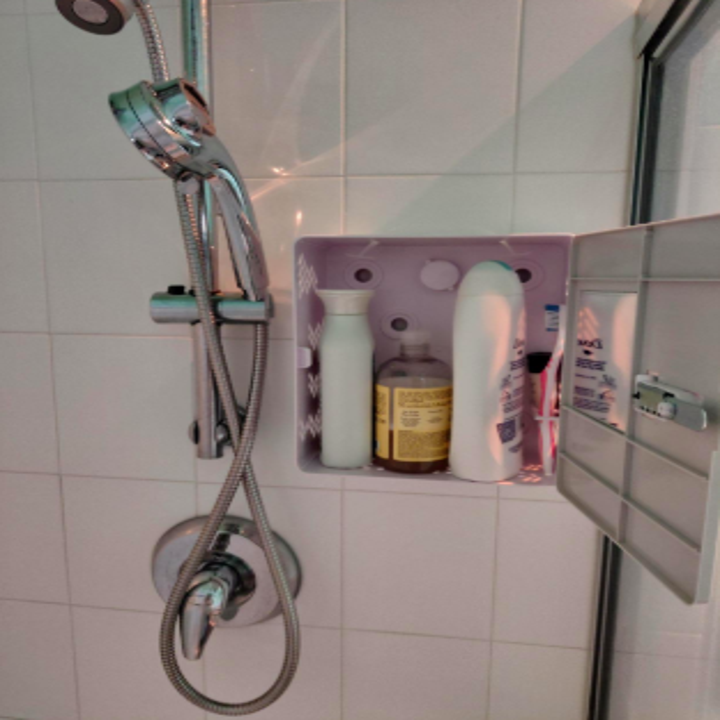 Reviewer photo of the locker in a shower with the door open and bottles inside