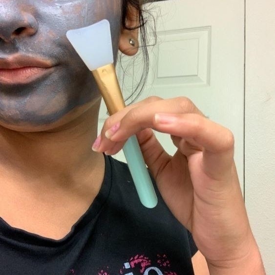 reviewer applying face mask with silicone spatula 
