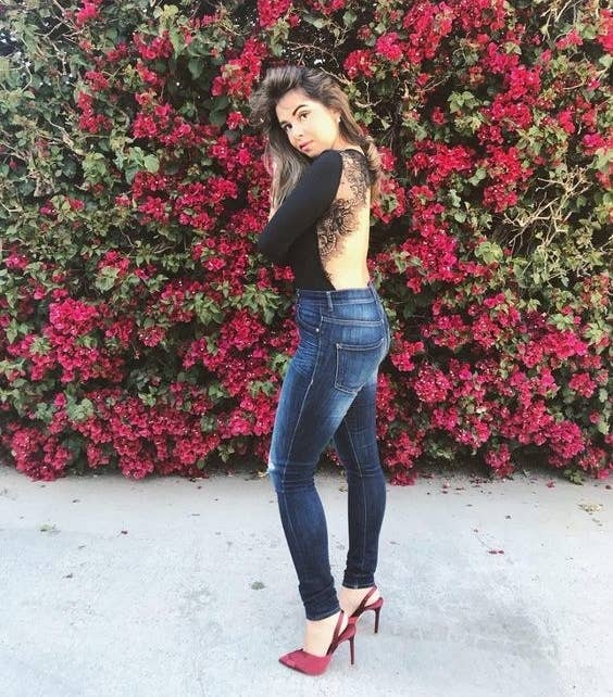 reviewer wearing backless body suit with jeans and red heels 