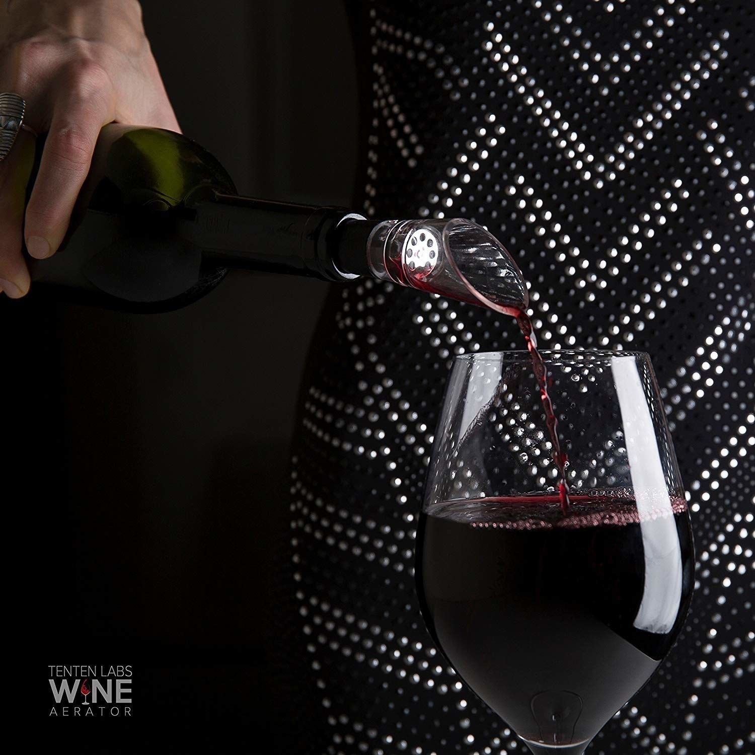 bottle of wine being poured with wine pourer spout on top 