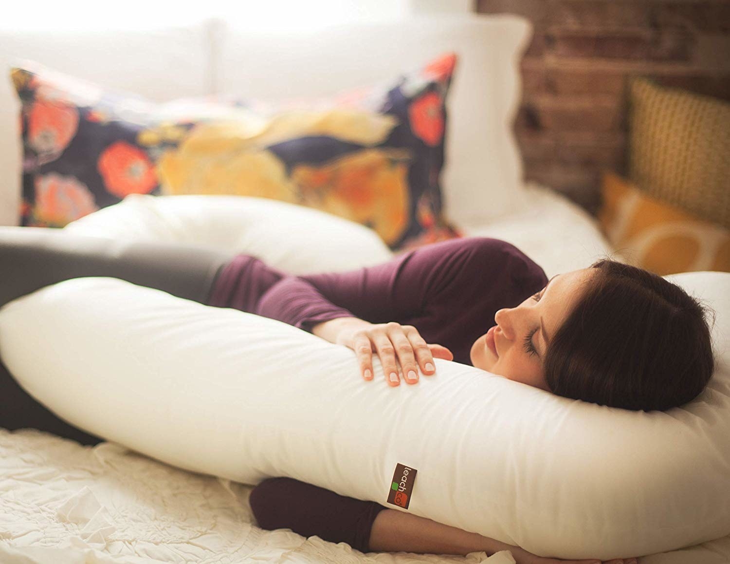 a model cuddled up with a full body pillow