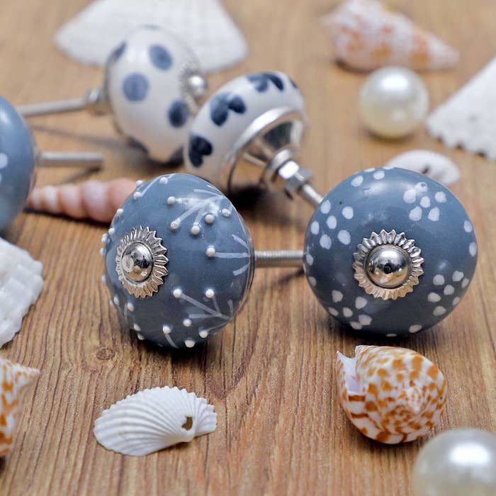A close-up of the hand-painted globular knobs next to some seashells