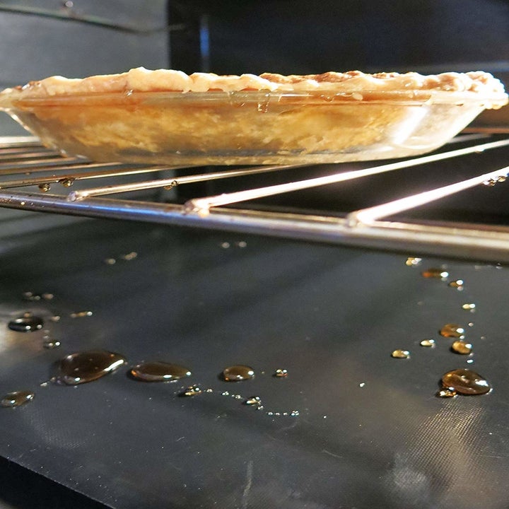 The oven liners catching drippings from a pie