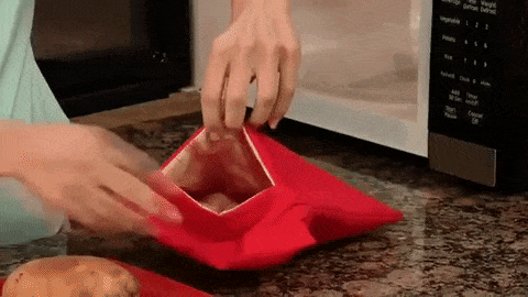Gif of hands inserting the potato into the bag, putting the bag in the microwave, and removing the cooked potato from the bag