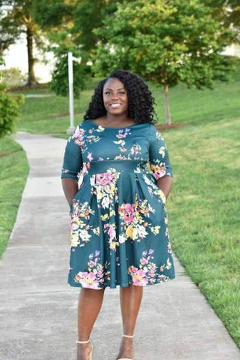 reviewer wearing the dress in green with pink and yellow flowers 