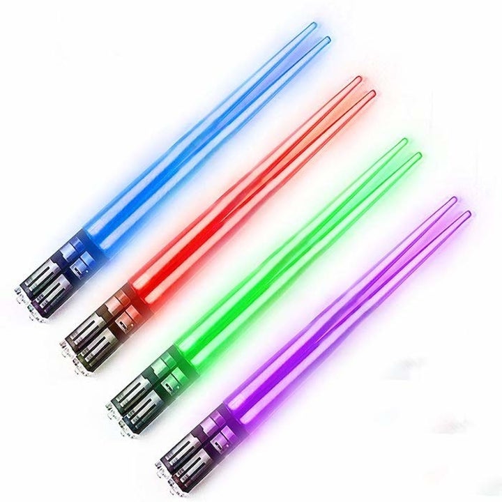 four pairs of chopsticks shaped like the Lightsabers. They're lit up in blue, red, green, and purple respectively