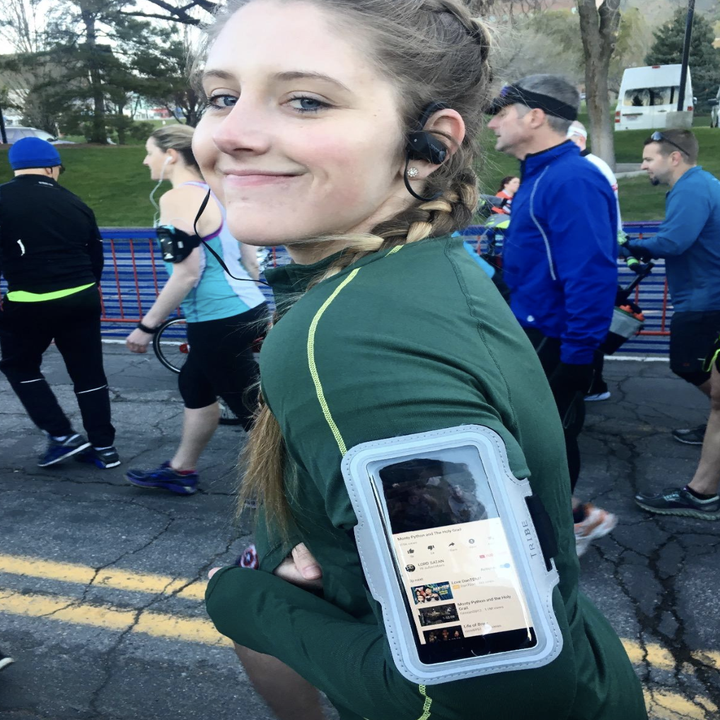 reviewer wearing the clear case with pastel blue trim on their arm