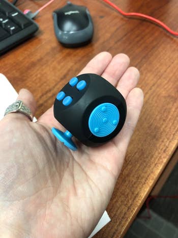 reviewer holding the black cute with blue buttons