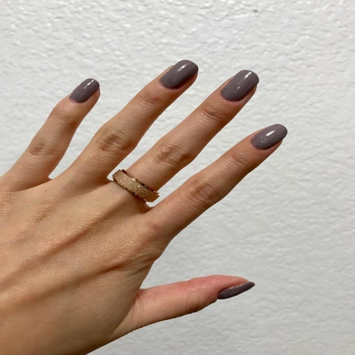 reviewer wearing the gold textured ring on their middle finger